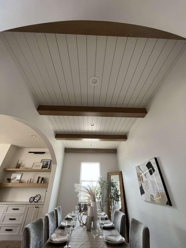 Tongue and groove ceiling with decorative beams and arched opening