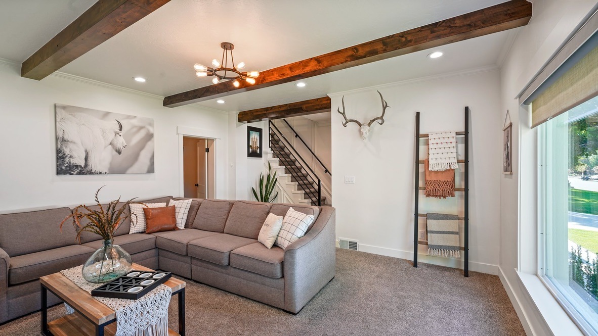 Living room with ceiling beams and stair rail
