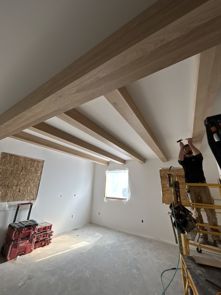 Crew installing custom ceiling beams on site